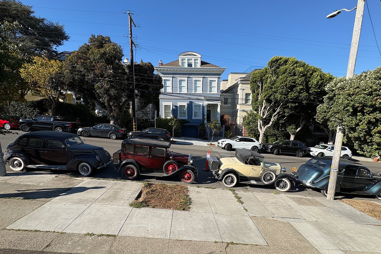 Film shoot takes over San Francisco street with 1930s cars, simulated rain